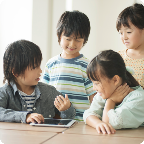 タブレットを見ながら会話している子供たち